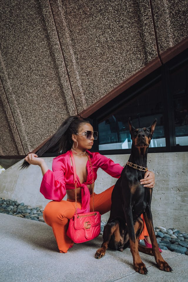 modelo posando para foto com cão da raça dobermann pinscher